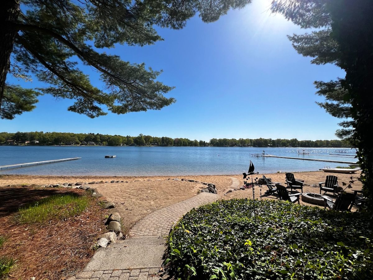 A sandy path through pine boughs leading down to the lake at the MCM Lake House in Twin Lake
